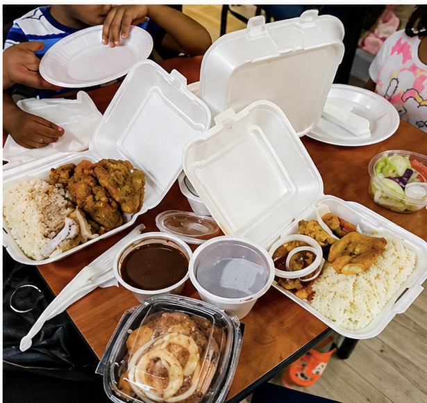 A spread of Haitian dishes including griot, rice and beans, plantains and pikliz